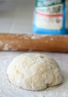 a ball of dough sitting on top of a floured surface next to a rolling pin