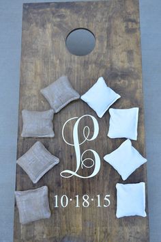 a personalized cornhole board with pillows and linens on the bottom that says, j & b