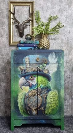 a green and blue cabinet with a clock on it's side, next to a deer head