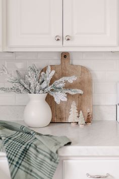 a kitchen counter with a cutting board on top of it and christmas decorations in the corner