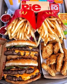 a tray filled with fries and hamburgers next to french fries on top of each other