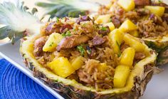 two pineapples with meat and rice on a plate