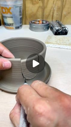 a person is making a vase out of clay