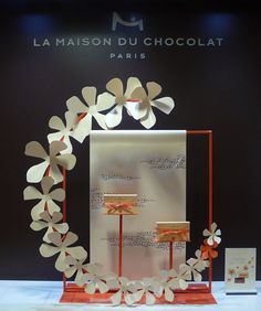 the display is decorated with paper flowers and ribbon around it's edges, along with an orange stand