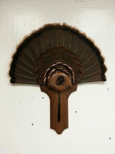 a wooden fan mounted to the side of a wall