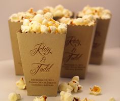 popcorn bags filled with white chocolate and sprinkles on top of a table