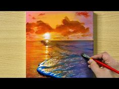 someone is painting a sunset over the ocean with watercolors on paper and colored pencils