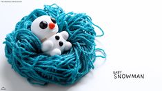 there is a blue ball of yarn with two small white dogs in it and the words baby snowman written below