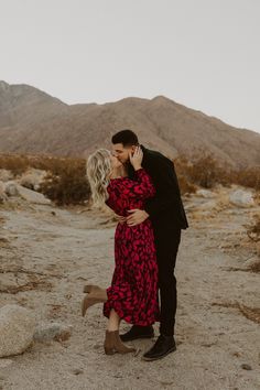 a man and woman kissing in the desert