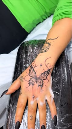 a woman's hand with a butterfly tattoo on it