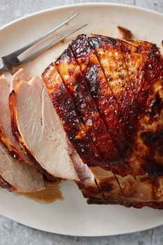 sliced pork on a plate with knife and fork