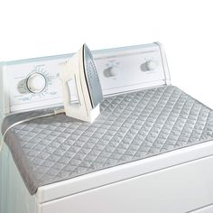 an electric dryer sitting on top of a white dresser