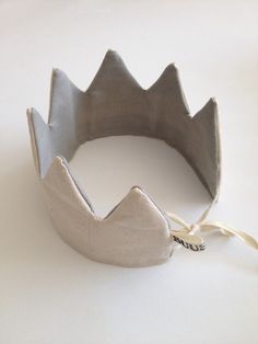 a metal crown sitting on top of a white table next to a string tied around it