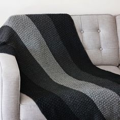 a couch with a black and grey blanket on it