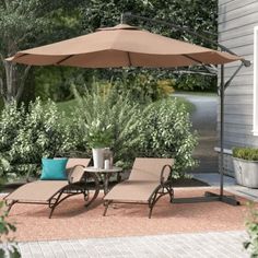 a patio with lounge chairs and an umbrella