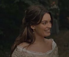 a woman in a white dress is smiling