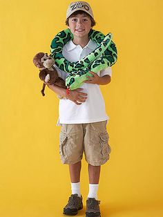 a young boy holding a stuffed animal in front of a yellow background with his arms wrapped around him