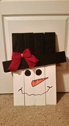 a paper bag with a snowman's face on it and a red bow