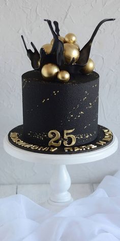 a black cake with gold decorations on top