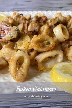 cooked calamari with lemon wedges on a white plate