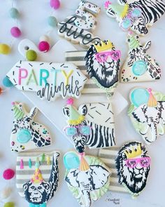 decorated cookies with party animals on them are arranged in the shape of zebras and lions