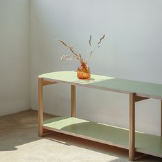 a vase with some flowers on top of a table in a room next to a window