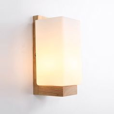 a light that is on the wall next to a white wall with a wooden frame