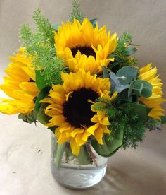 a vase filled with lots of yellow sunflowers