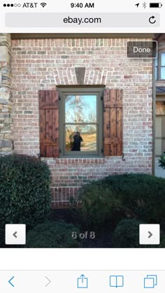 an image of a brick house with shutters open