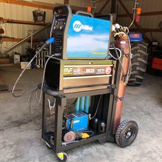 a machine that is sitting inside of a garage next to some tires and other equipment