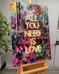 an easel with a painting on it that says, all you need is love