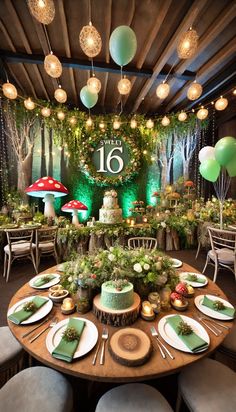 a table set up for a birthday party with balloons and greenery on the wall