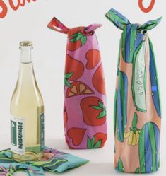 two wine bags, one with an apple print and the other has a bottle in it