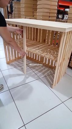 a person standing next to a table made out of pallets and wood planks