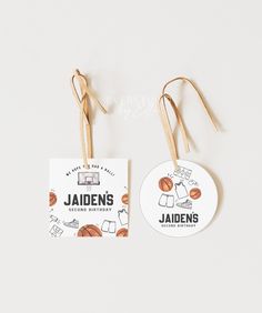 two luggage tags with the name jaden's behind them, hanging from strings