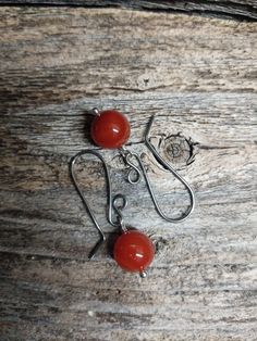 Choose your ear wire to go with these colorful Red Carnelian Bead dangles. The ear wires are available in sterling silver or two types of hypoallergenic wires. In the third picture the ear wires are starting on the left: sterling silver, niobium, titanium and oxidized titanium (I love the color of this last pair!). The red carnelian bead dangles are 10 mm across. They are hand wire wrapped with sterling silver. Made to order and ready to ship in 1-3 days. Red Agate Earrings As Gift, Red Agate Earrings For Gift, Red Carnelian Pierced Earrings, Carnelian Amber Earrings For Gift, Handmade Adjustable Carnelian Earrings, Amber Carnelian Earrings Gift, Agate Dangle Earrings With Ear Wire, Nickel-free Agate Earrings For Gifts, Nickel Free Carnelian Dangle Earrings