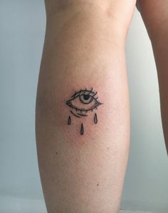 a woman's leg with a tattoo on it that has an eye and rain drops