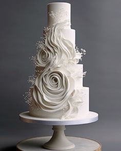 a three tiered white wedding cake with flowers on top