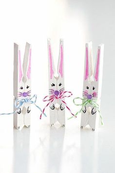 three bunny shaped paper bags tied to each other with colorful ribbons on the handles and ears