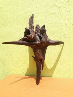 a piece of wood that has been placed on top of a wooden table with a yellow wall in the background