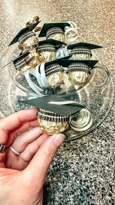 a person is holding scissors and some chocolates on a glass platter with gold foil