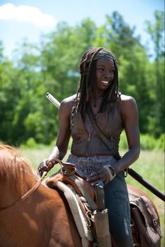 a woman sitting on top of a brown horse