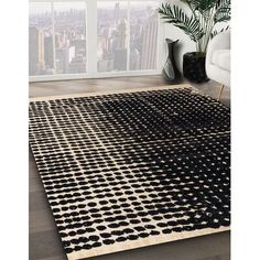 a black and white area rug in front of a window with cityscape behind it