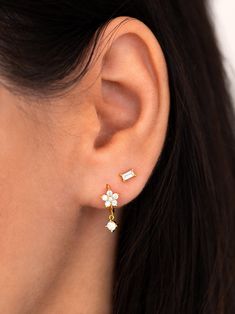 "These tiny flower hoop earrings feature a sparkly CZ flower and a dangling cz charm. A dainty and elegant pair that looks gorgeous layered with other earrings, but is just as beautiful worn alone for a more minimal look. Can also be worn on a cartilage/helix piercing. ∙ Sold individually (1 earring) or as a pair (2 earrings) * D E T A I L S * ∙ Material: .925 Sterling Silver or 18K Gold Plated over .925 Sterling Silver ∙ Inner diameter: 8mm // Flower: 6mm ∙ Hypoallergenic & nickel-free * P Cartilage Helix Piercing, Baguette Studs, Tiny Gold Studs, Baguette Earring, Flower Hoop Earrings, Dainty Hoop Earrings, 2 Earrings, Dainty Studs, Tiny Stud Earrings