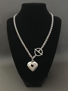 a necklace with a heart on it and a letter charm hanging from the middle chain