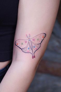 a woman's arm with a butterfly tattoo on the left side of her body