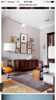 a living room filled with furniture and framed pictures on the wall above an entertainment center