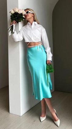 Here is a woman in a white shirt and blue skirt