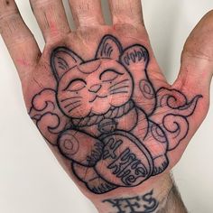 a person's hand with a cat tattoo on it