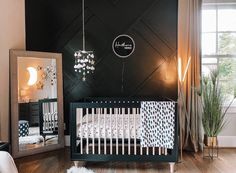 a baby's room with a crib, mirror and plant in the corner